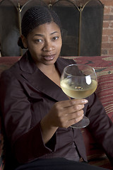 Image showing smiling woman on sofa with wine glass