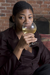 Image showing smiling woman on sofa with wine glass