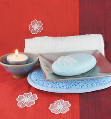 Image showing Burning candle and white flowers with soap in a dish