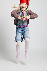 Image showing Happy girl jumping while holding Christmas gifts