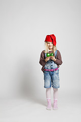 Image showing Smiling girl wearing Christmas hat and holding baubles