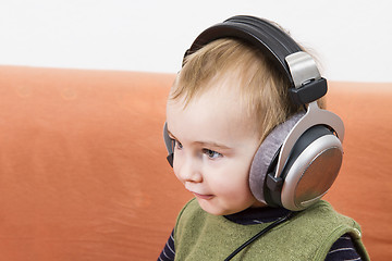 Image showing young child on couch with headphone