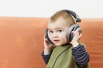 Image showing young child on couch with headphone