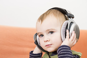 Image showing young child on couch with headphone