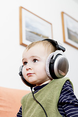 Image showing young child on couch with headphone