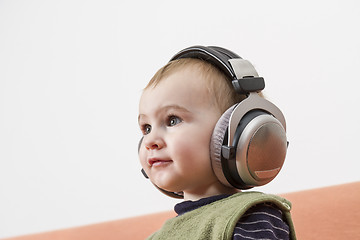 Image showing young child on couch with headphone