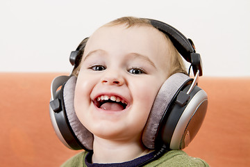 Image showing young child on couch with headphone