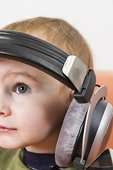 Image showing young child on couch with headphone