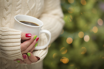 Image showing Woman with Red and Green Nail Polish Holding Cup of Coffee