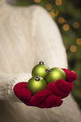 Image showing Woman Wearing Seasonal Red Mittens Holding Green Christmas Ornam