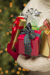 Image showing Woman Wearing Seasonal Red Mittens Holding Christmas Gifts