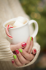 Image showing Woman with Red and Green Nail Polish Holding Cup of