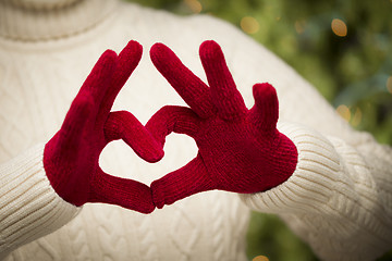 Image showing Woman Wearing Red Mittens Holding Out a Heart Hand Sign