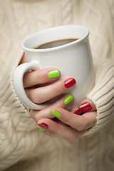 Image showing Woman with Red and Green Nail Polish Holding Cup of Coffee