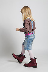 Image showing Young girl walking in adult sized boots