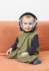 Image showing young child on couch with headphone