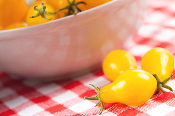 Image showing yellow tomatoes on picnic tablecloth