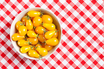 Image showing yellow tomatoes on picnic tablecloth