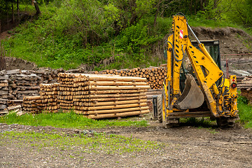 Image showing Construction machine and a pile of boards