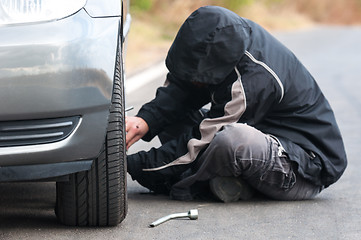 Image showing Young man repairing car outdoors