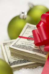 Image showing Stack of Hundred Dollar Bills with Bow Near Christmas Ornaments