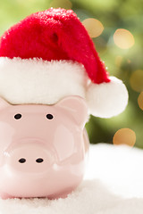 Image showing Pink Piggy Bank with Santa Hat on Snowflakes