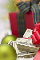 Image showing Stack of Hundred Dollar Bills with Bow Near Christmas Ornaments