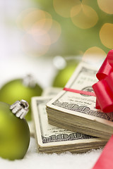 Image showing Stack of Hundred Dollar Bills with Bow Near Christmas Ornaments