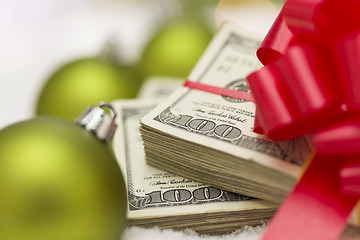 Image showing Stack of Hundred Dollar Bills with Bow Near Christmas Ornaments