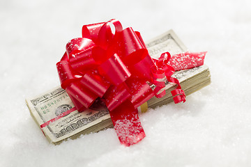 Image showing Stack of Hundred Dollar Bills with Red Ribbon on Snow