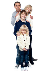 Image showing Affectionate family of four standing in a row