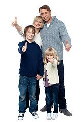 Image showing Adorable family in winter clothes gesturing thumbs up