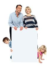 Image showing Lively family of four all around blank whiteboard