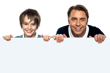 Image showing Father and son posing behind big blank banner ad