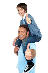 Image showing Confident father carrying his son on shoulder