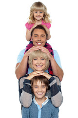 Image showing Attractive smiling family of four posing in a single line