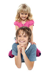 Image showing Adorable sister sitting on her brothers back