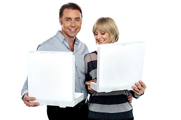 Image showing Middle aged couple holding white pizza boxes