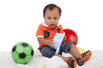 Image showing One year old baby boy enjoys playing with toys. Studio Shot. 