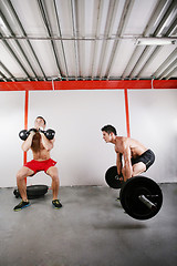 Image showing Group of two people exercising using barbells in gym and kettleb