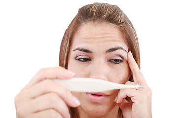 Image showing Sick woman looking at a clinical thermometer 