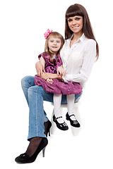 Image showing mother with a cute daughter sitting on a chair