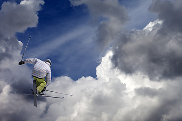 Image showing Freestyle ski jumper with crossed skis against blue sky with clo