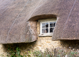 Image showing Small wooden window under thatched roof