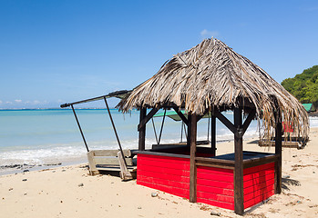 Image showing Table and chairs covered by sand on beach