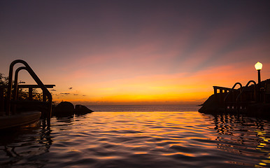 Image showing Infinity edge pool with sea underneath sunset