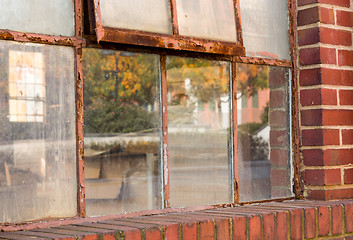 Image showing Old rusty window in warehouse reflecting fall