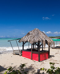 Image showing Table and chairs covered by sand on beach