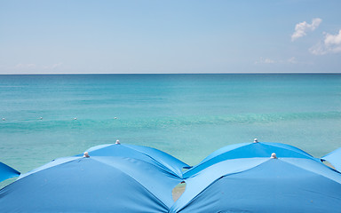 Image showing Four beach umbrellas on beach