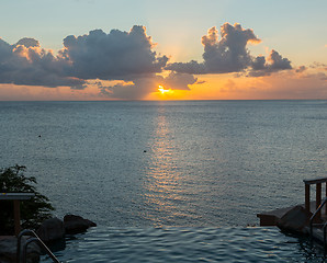 Image showing Infinity edge pool with sea underneath sunset